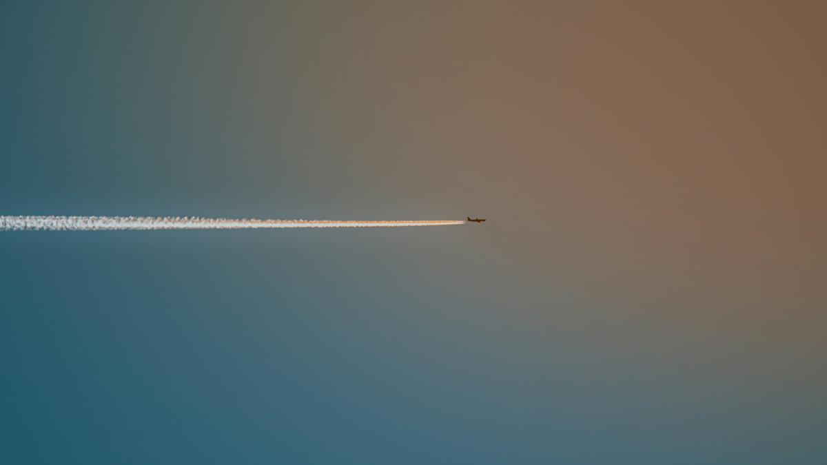 A plane leaves a vapor trail across the sky.