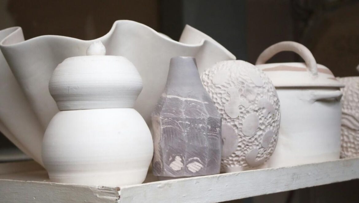 White ceramic pots and vases are neatly arranged.