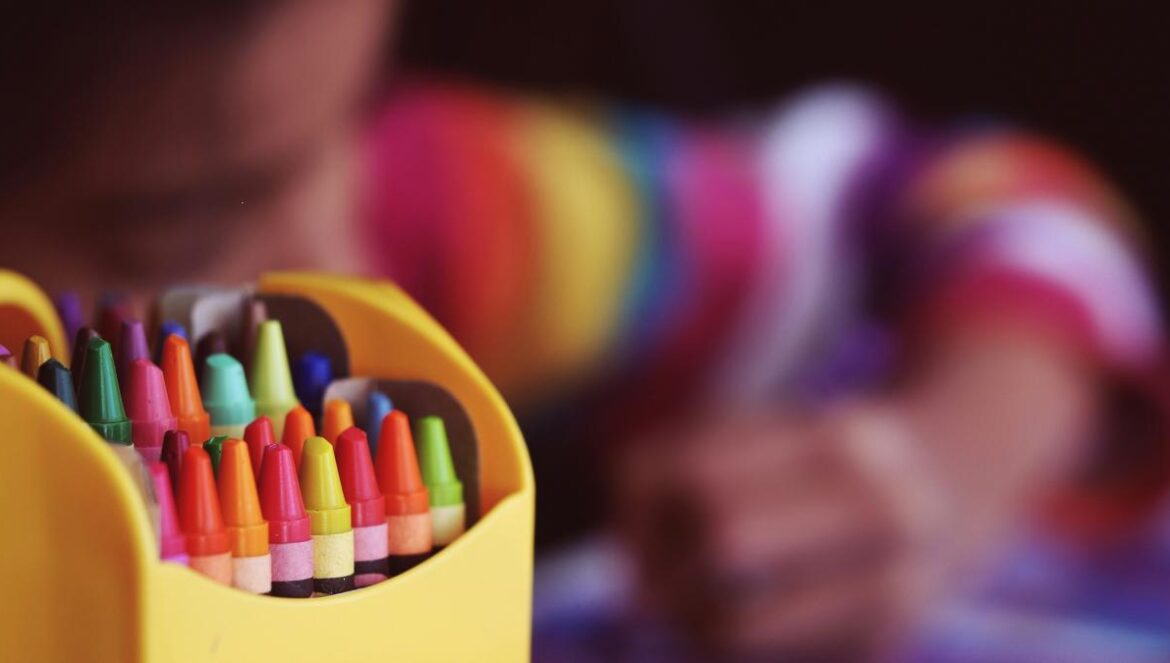 selective focal photo of crayons in yellow box