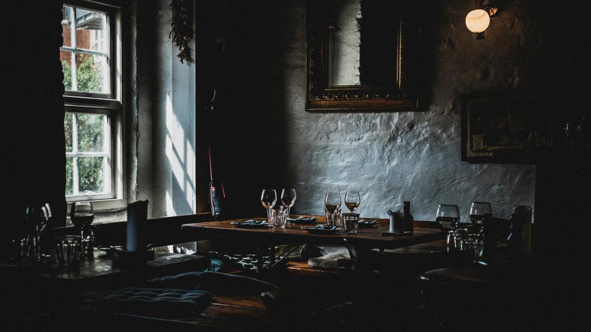 wine glasses on top of brown table near window