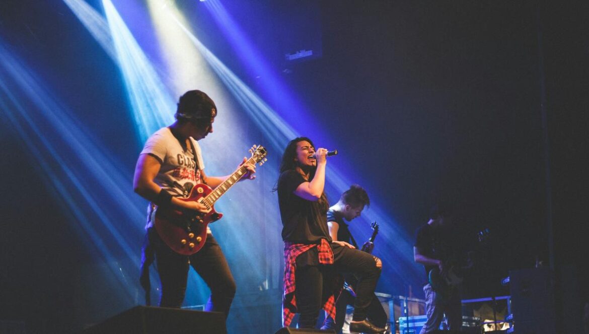 photo of male band performing on stadium