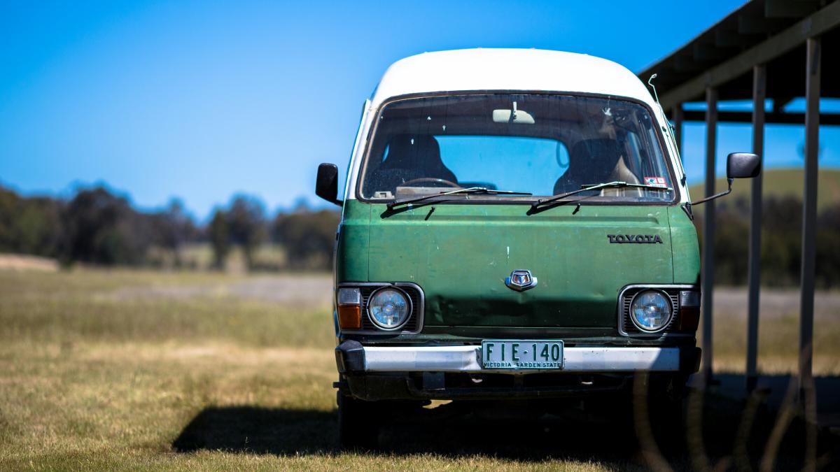 green and white Toyota vehicle parked near shed