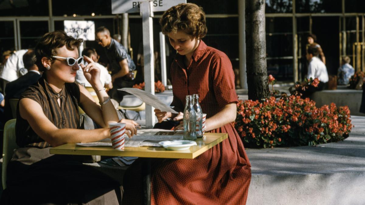 woman sitting in front of table with two empty glass bottles