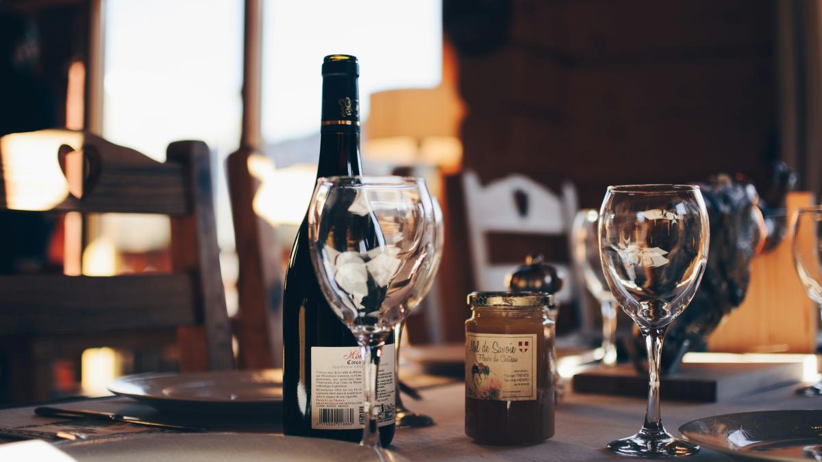 closeup photo of two empty wine glasses beside wine bottle