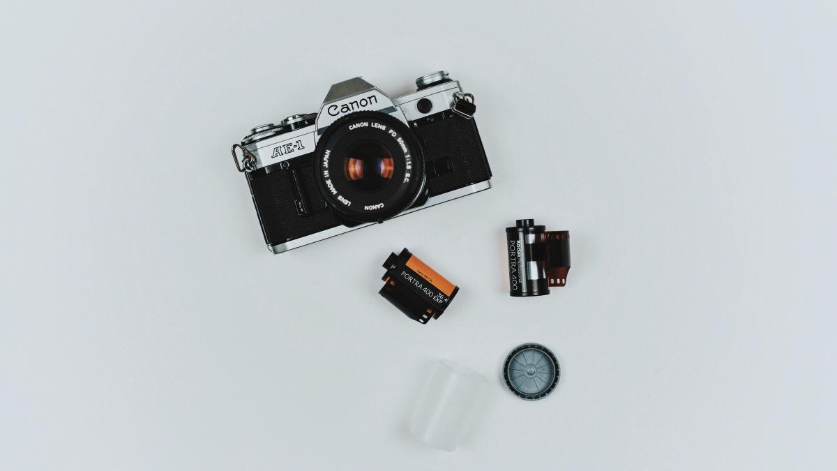 black Canon film camera with two films in flat lay photography