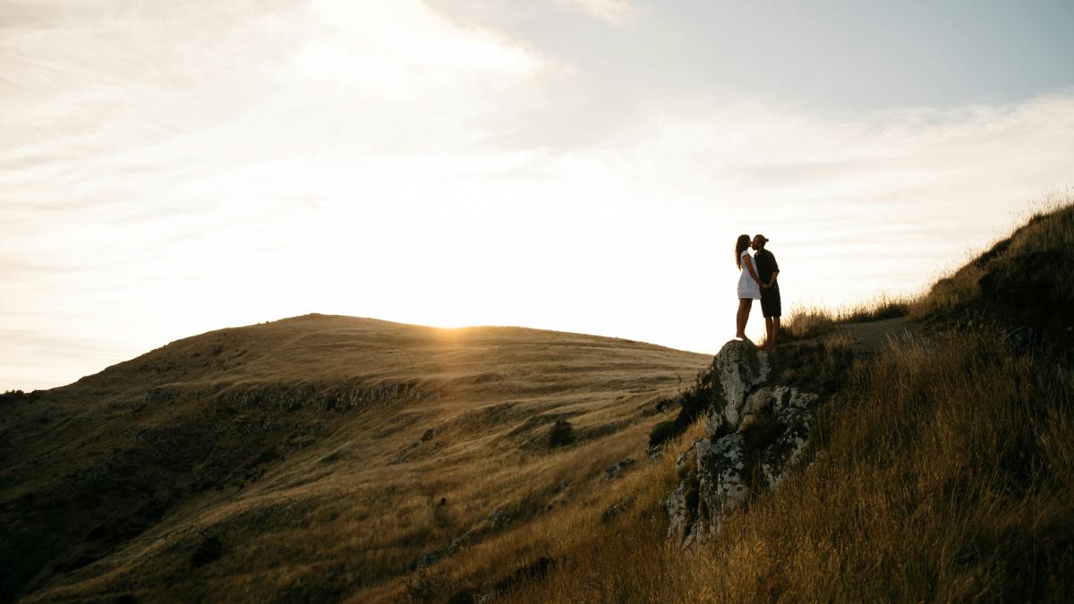 couple kissing on top of hill