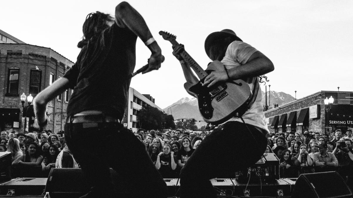 grayscale photo of man playing guitar