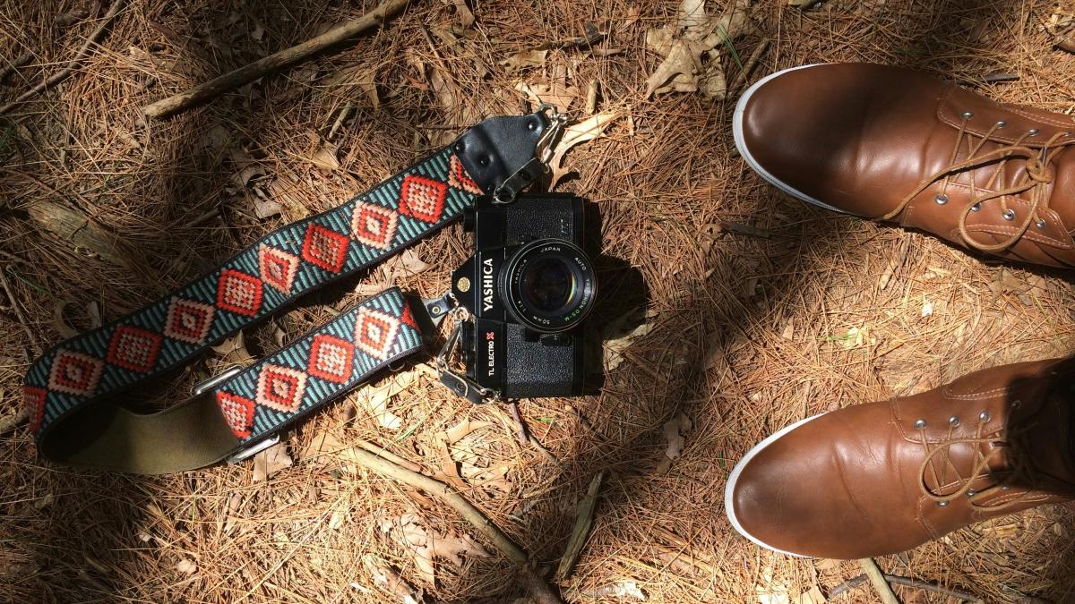 black DSLR camera on brown sand