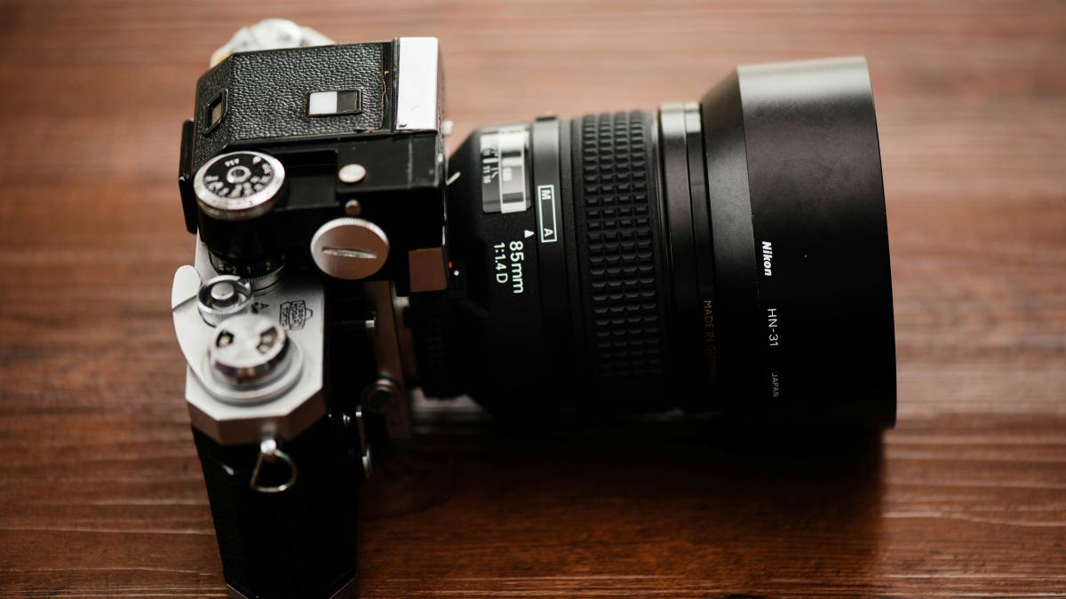 black SLR camera on brown wooden table