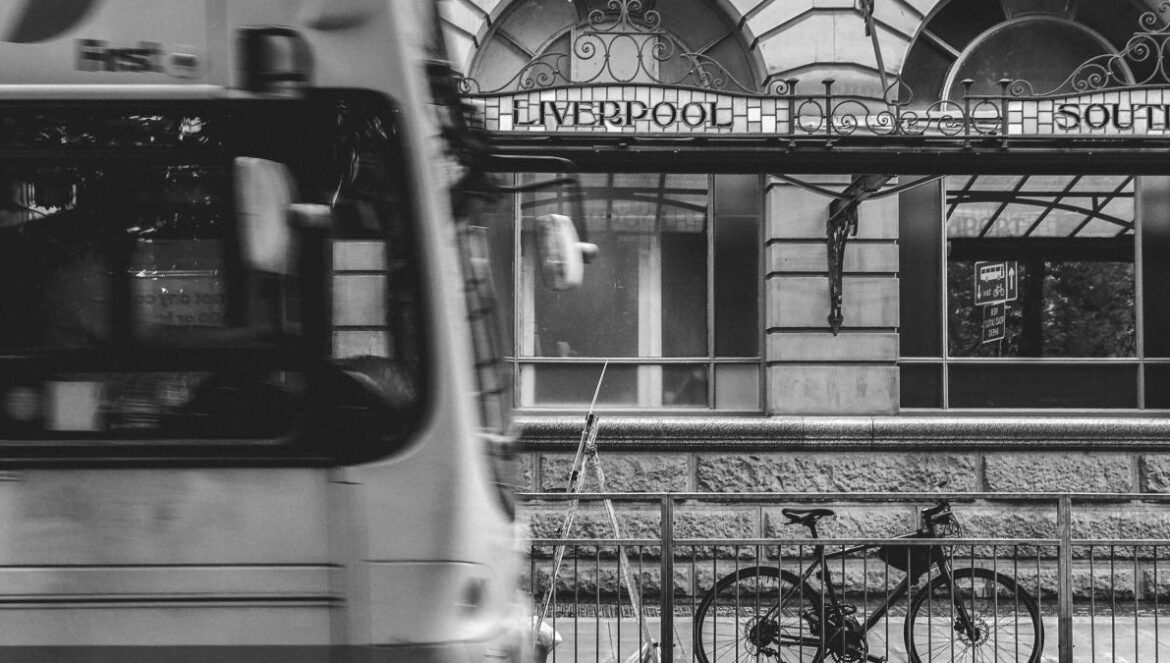 grayscale photography of bicycle parked at steel fence