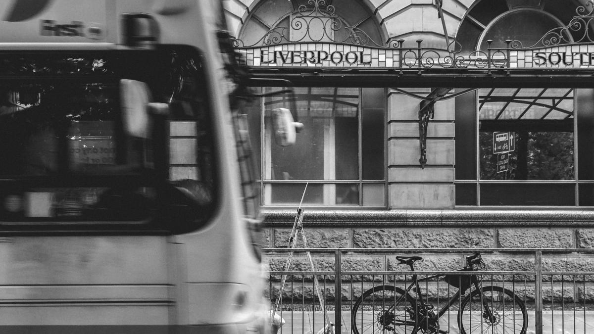 grayscale photography of bicycle parked at steel fence