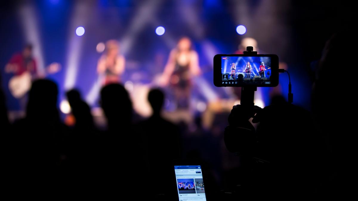 people taking videos during concert