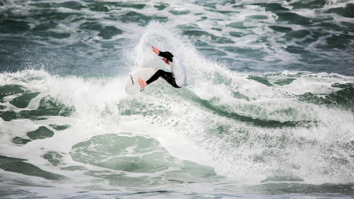 person surfing on beach during daytime photo