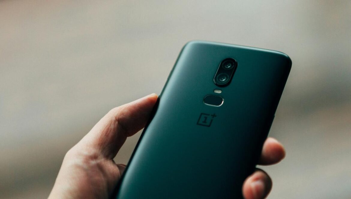 person holding black 1+ Android smartphone