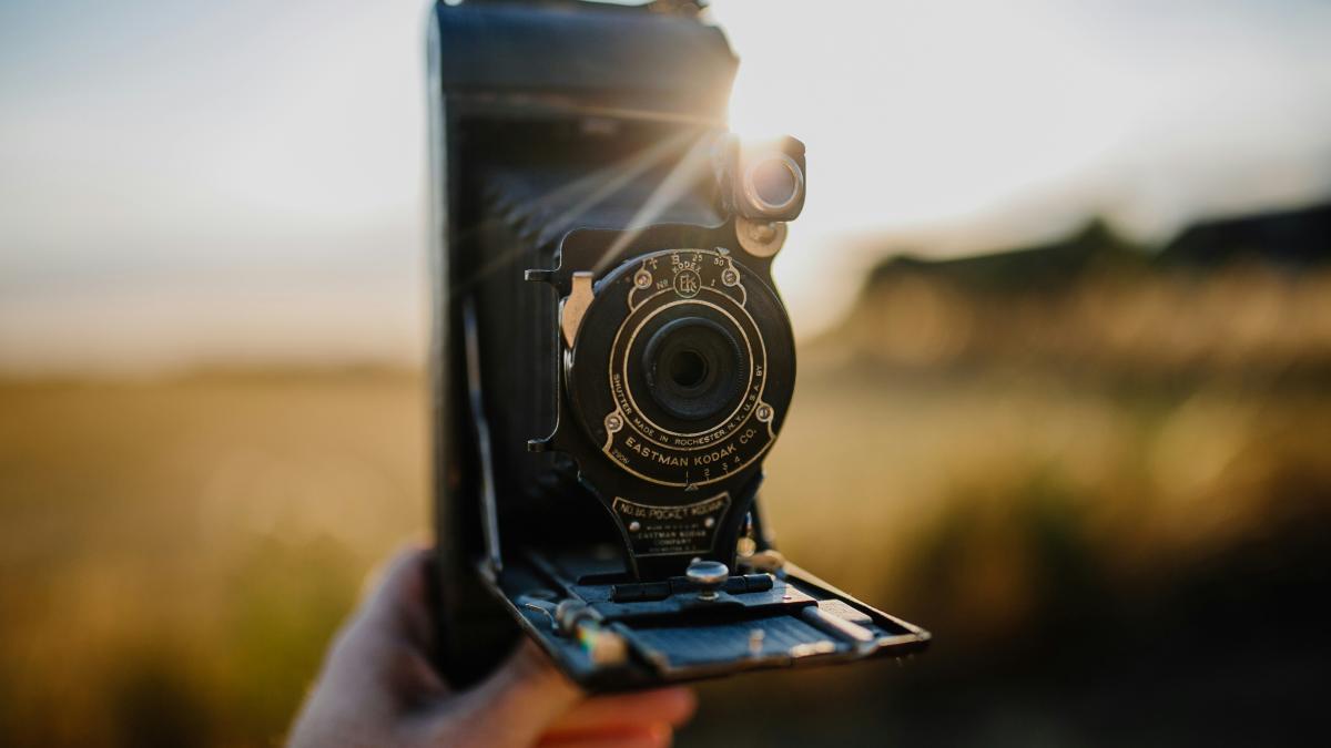 person holding black folding camera