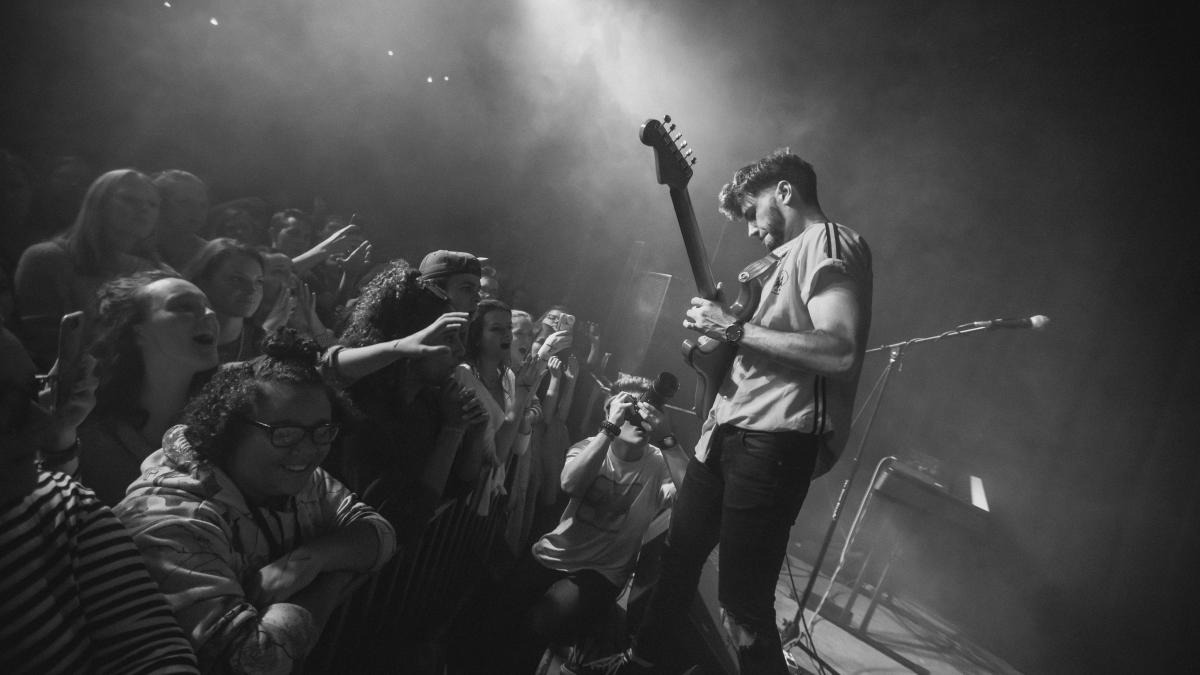 man playing guitar facing fans