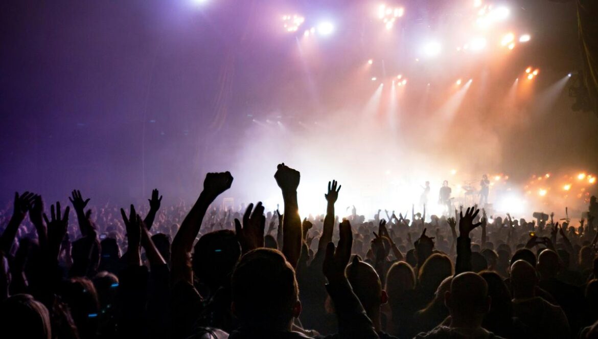 crowd facing lighted stage