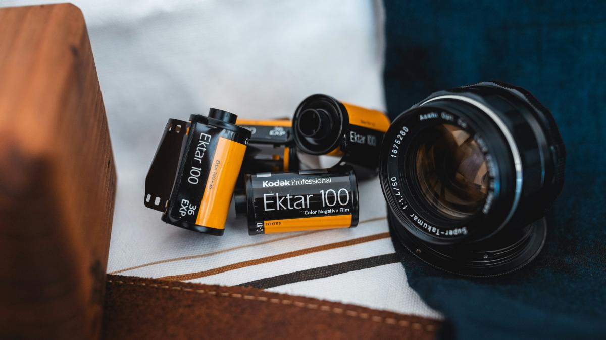 black webcam and Ektar 100 films on white textile