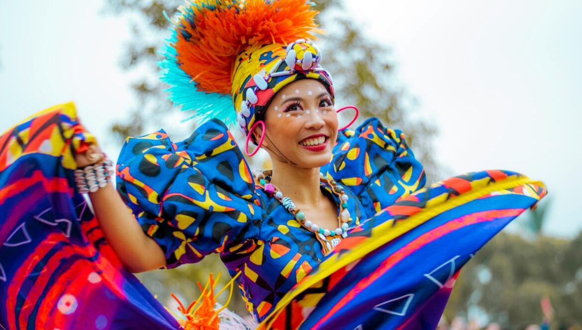 smiling woman wearing multicolored dress dancing outdoor during daytime