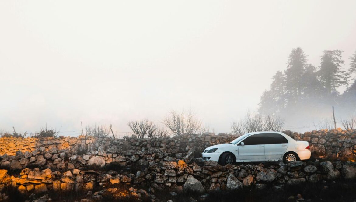 white Pontiac sedan parked near rock formation