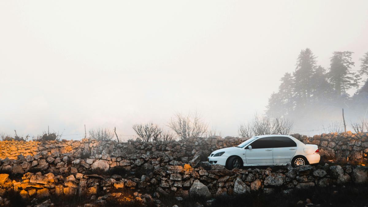 white Pontiac sedan parked near rock formation