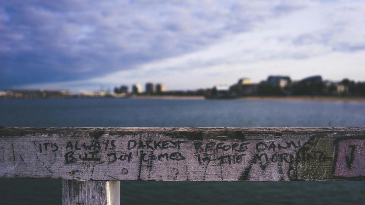 white rail with "It's Always Darkest Before Dawn But Joy Comes in the Morning" texts