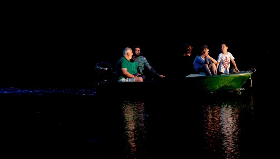 a group of people sitting in a green boat