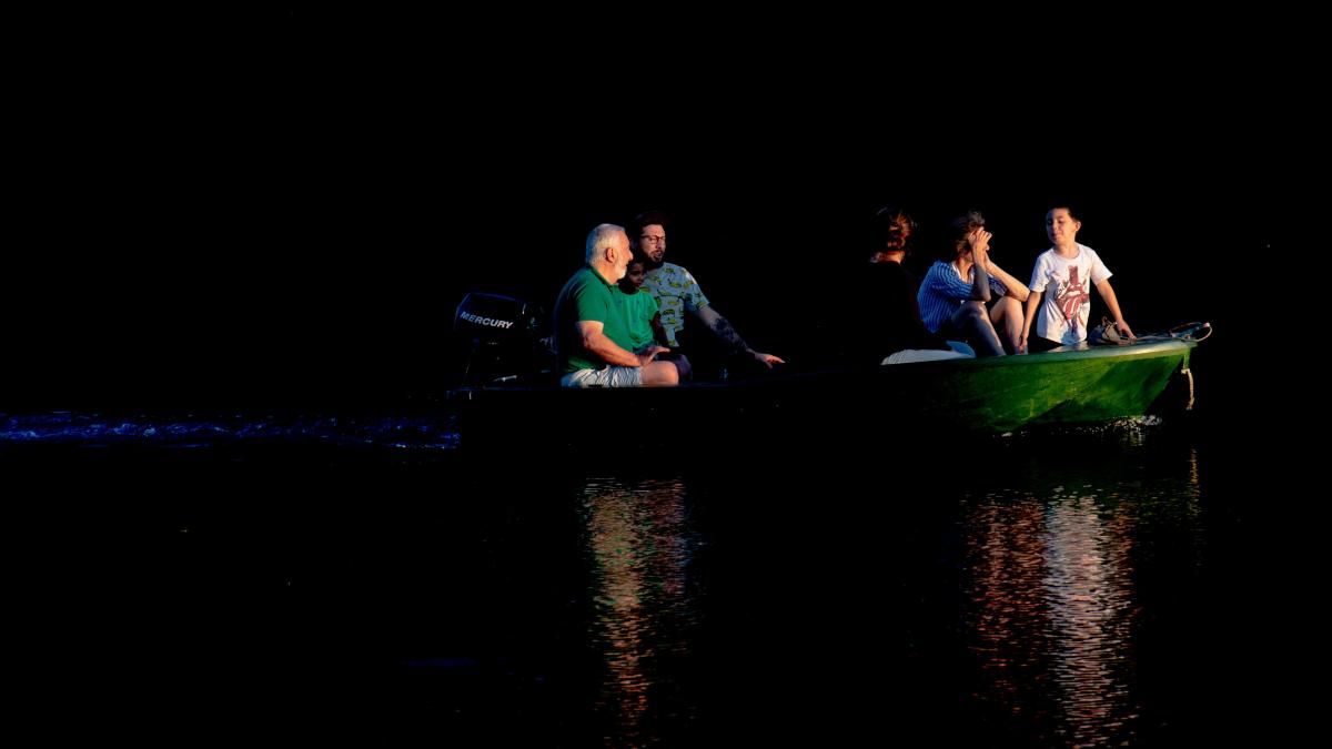a group of people sitting in a green boat