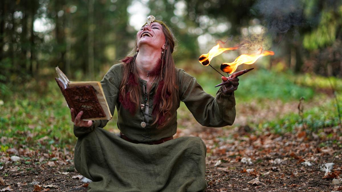 woman holding book and fire