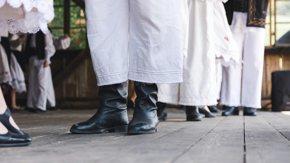 person in black leather boots standing on gray concrete floor