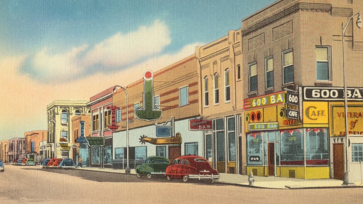 red car parked beside brown concrete building during daytime