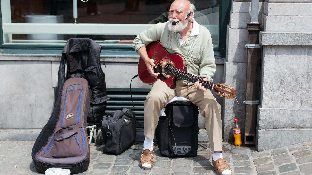 man in white dress shirt playing guitar