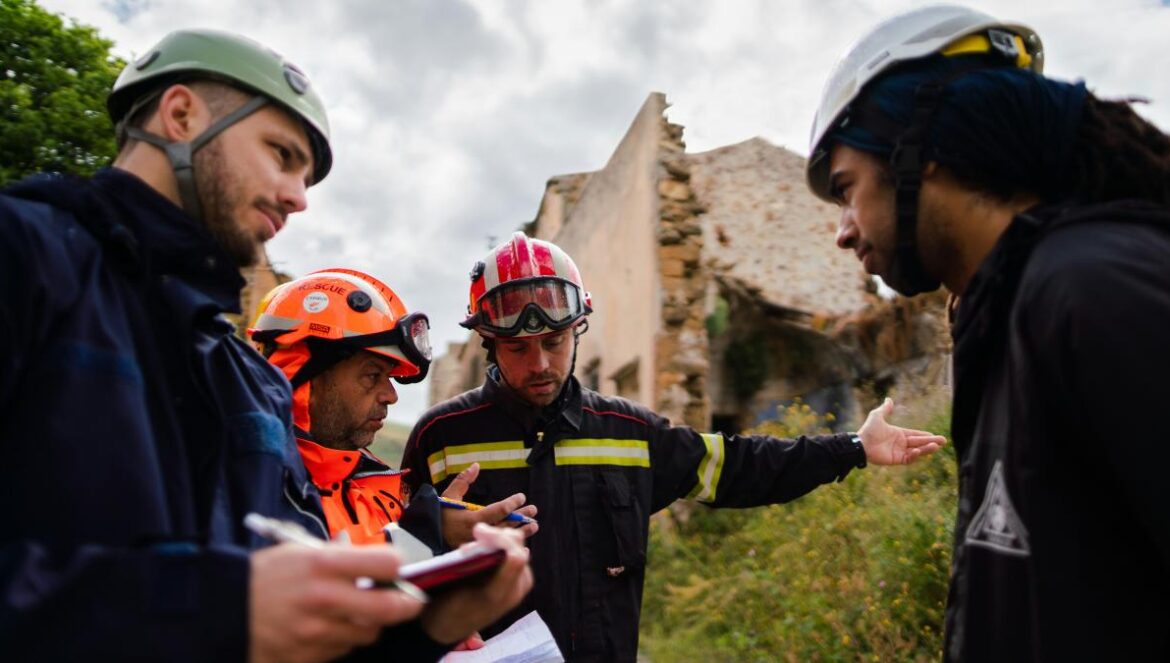 2 men in blue and orange jacket wearing helmet