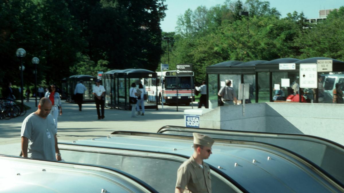 man in white shirt standing near black car during daytime