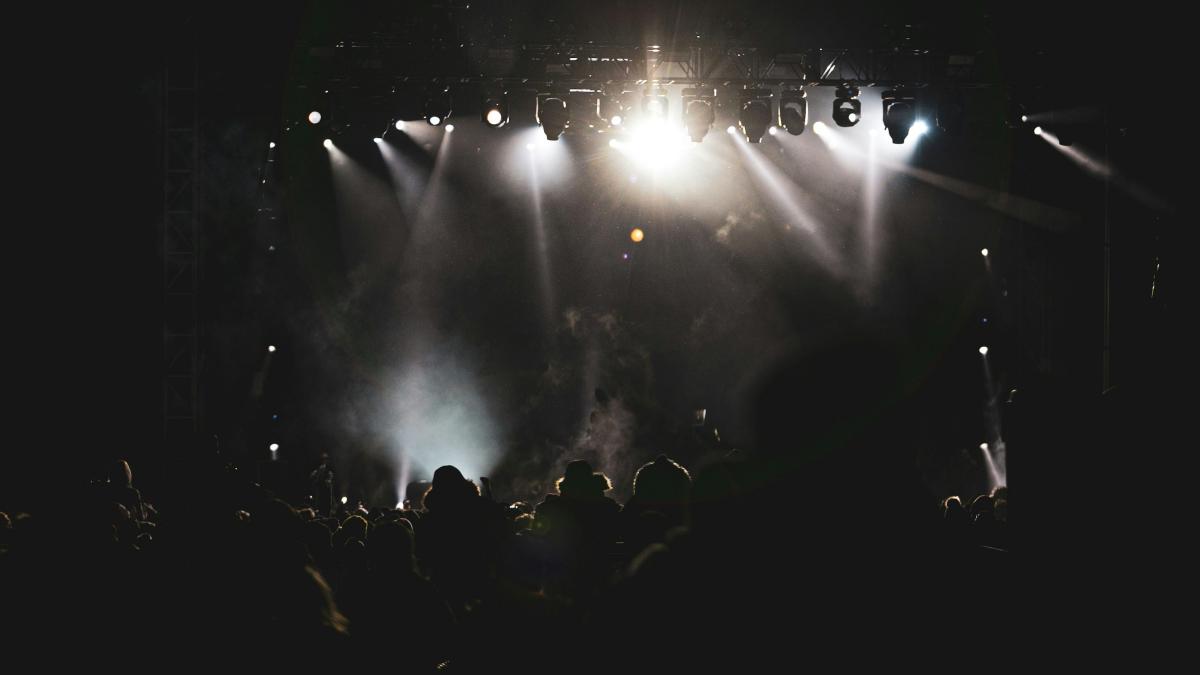 silhouette of people standing on the ground with lights