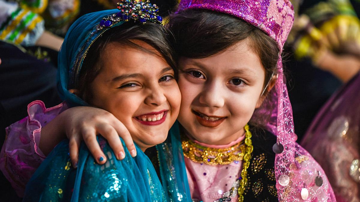 2 girls smiling wearing blue and purple floral dress