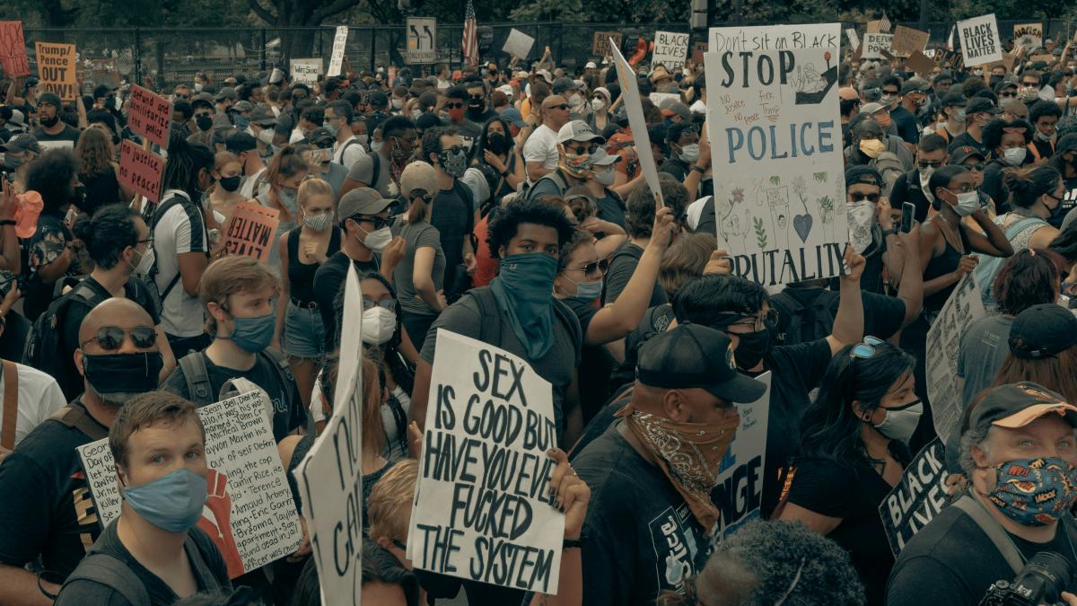 people holding white and black signage during daytime