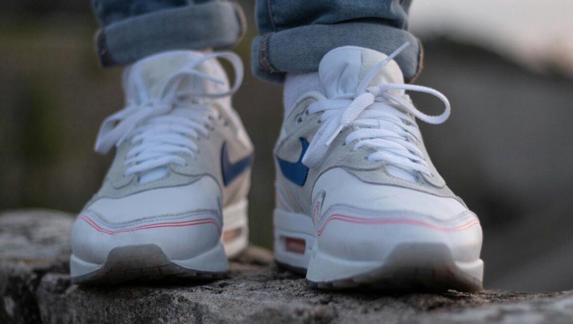 person in blue denim jeans wearing white and purple nike sneakers