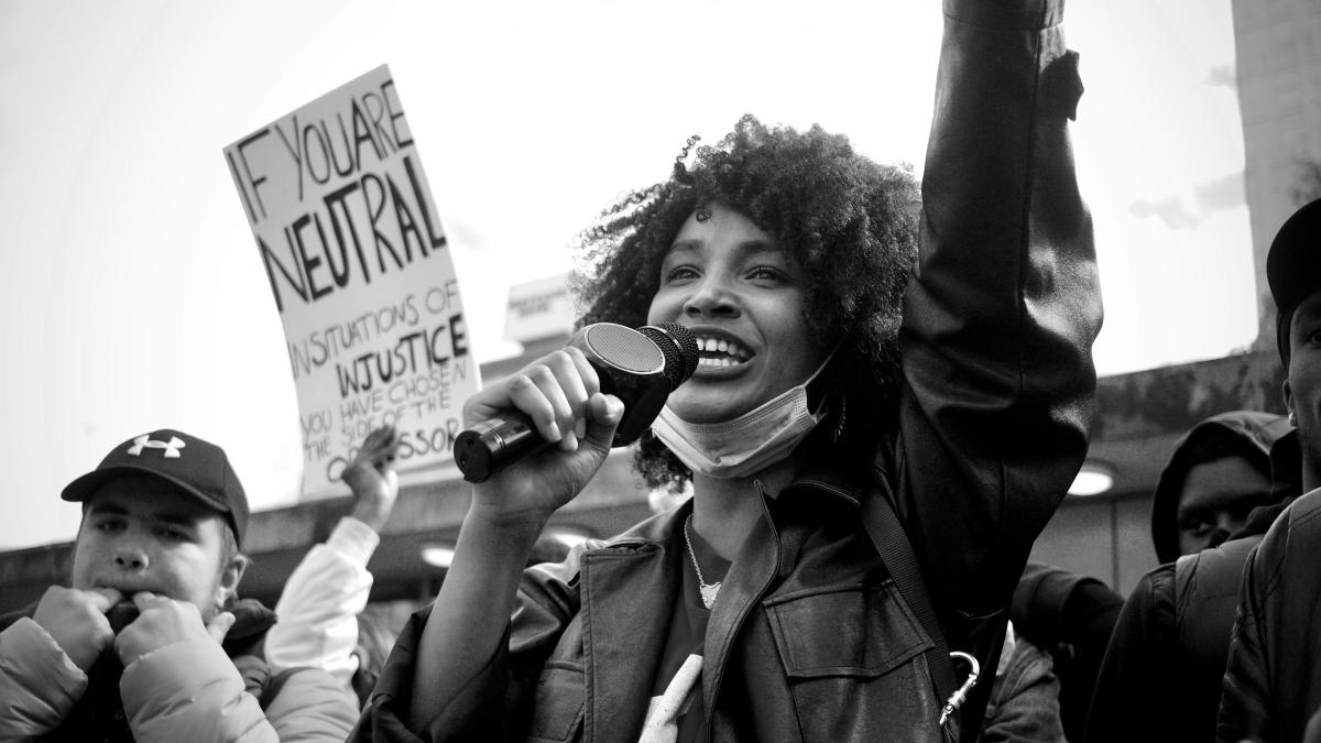 grayscale photo of man in black jacket holding black smartphone