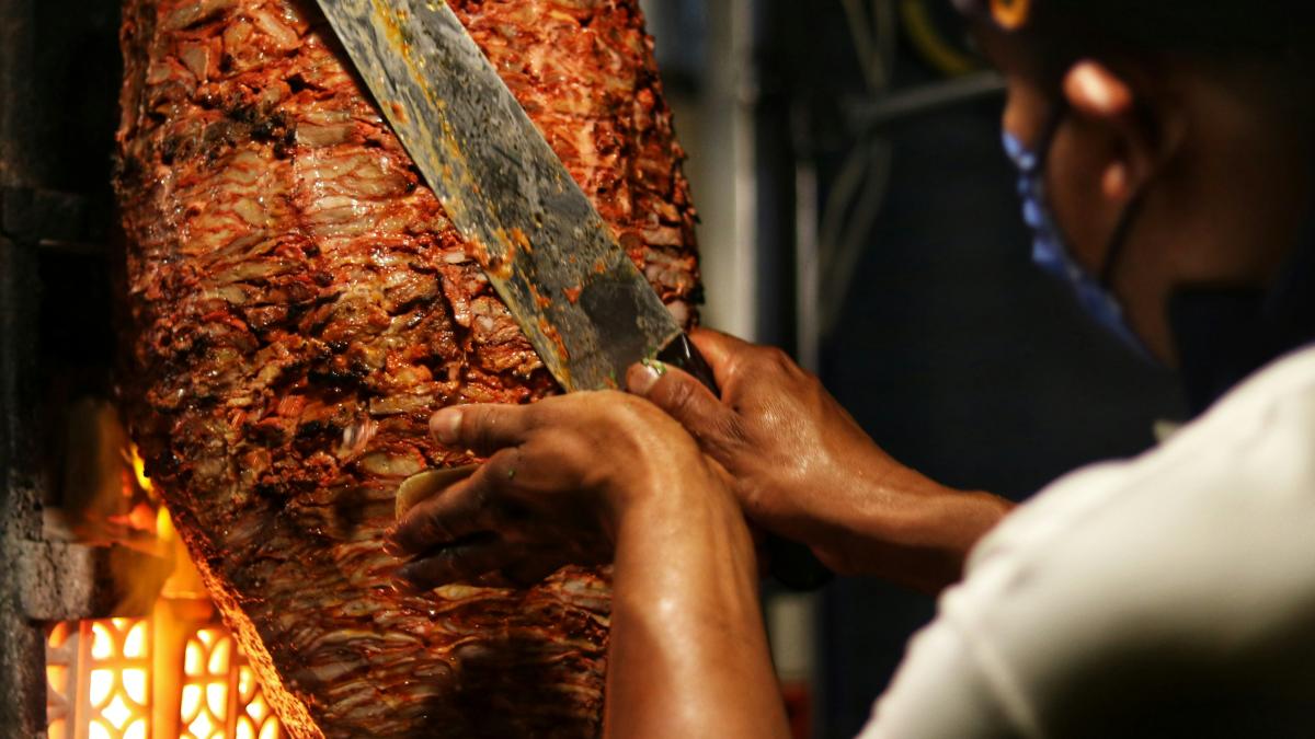 person holding sliced meat during daytime