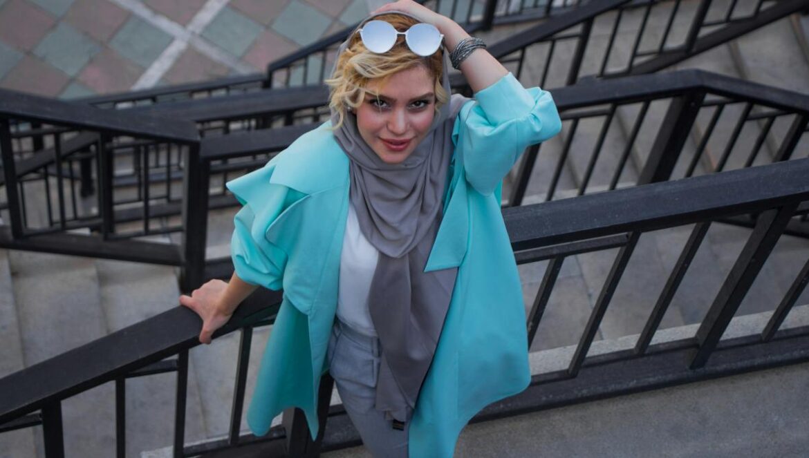 woman in blue coat wearing black sunglasses