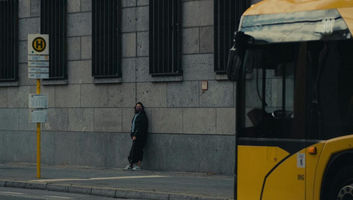 man in black jacket walking on sidewalk during daytime