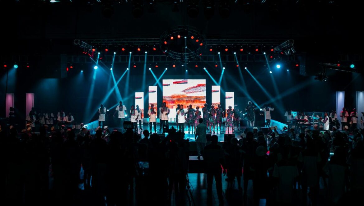 people standing on stage with lights turned on during night time