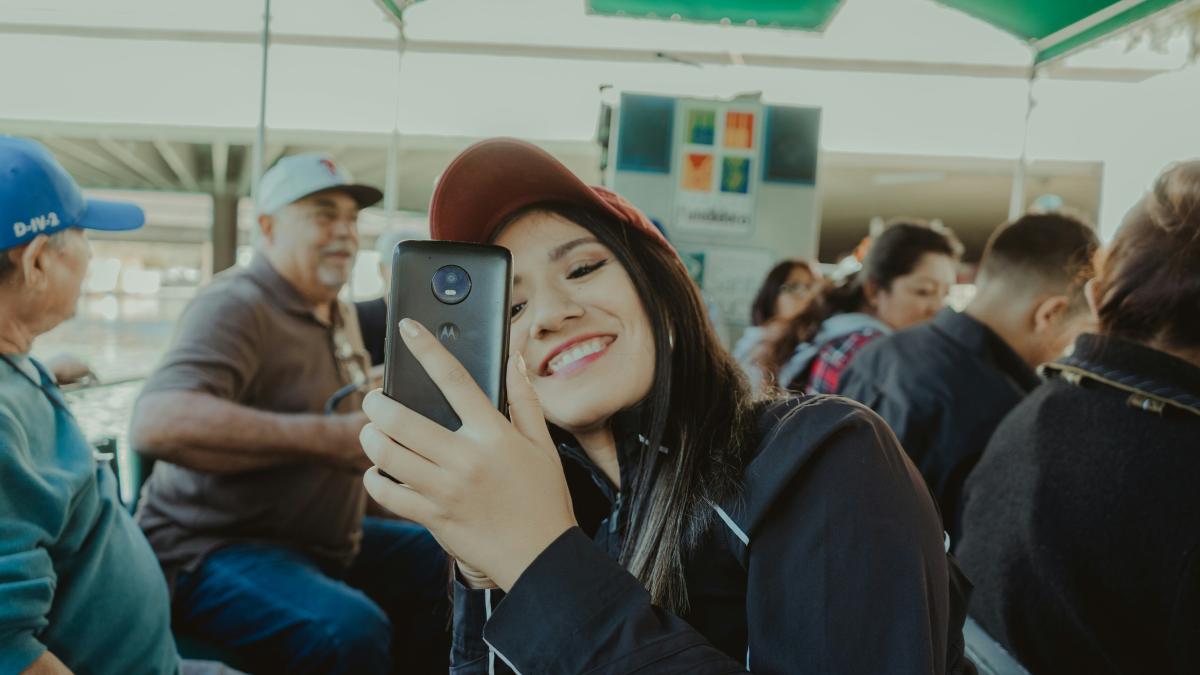 woman in black long sleeve shirt holding black smartphone