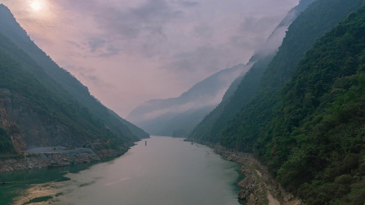 green mountains beside river under cloudy sky during daytime