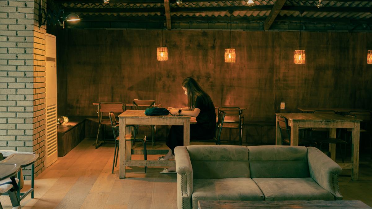woman in black long sleeve shirt sitting on gray couch