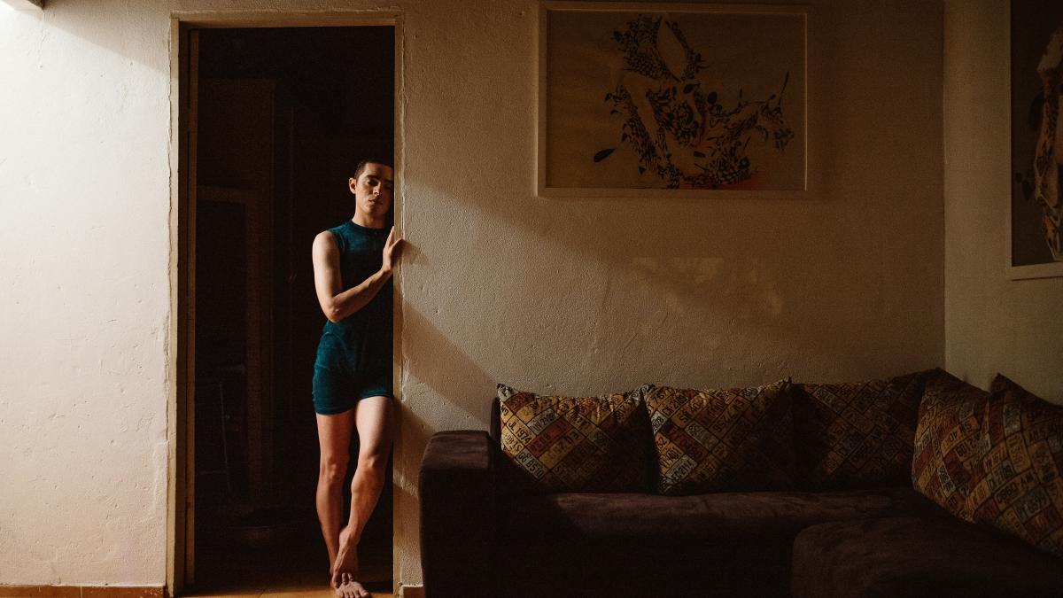 woman in blue tank top and blue shorts standing on black couch
