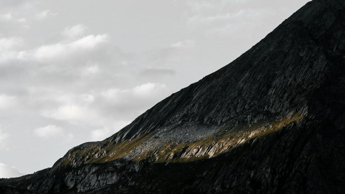 black and white mountain under white clouds