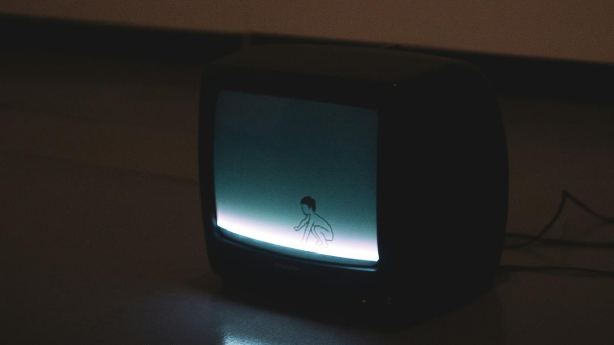 black crt tv turned on on brown wooden table