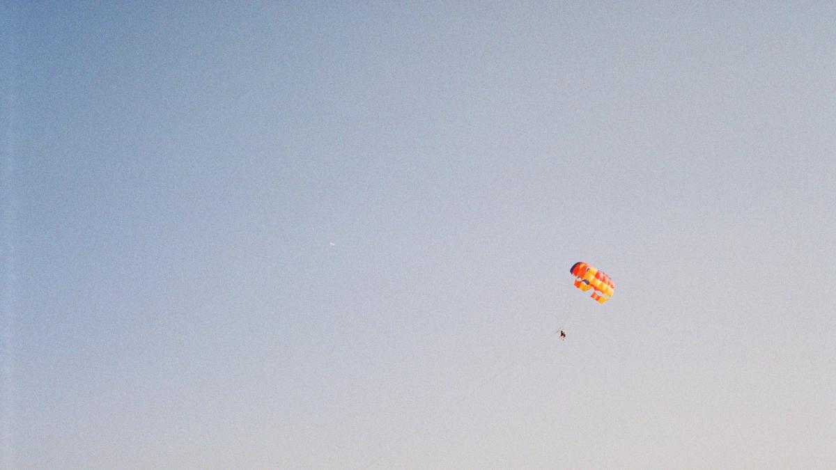 red and yellow parachute under blue sky during daytime